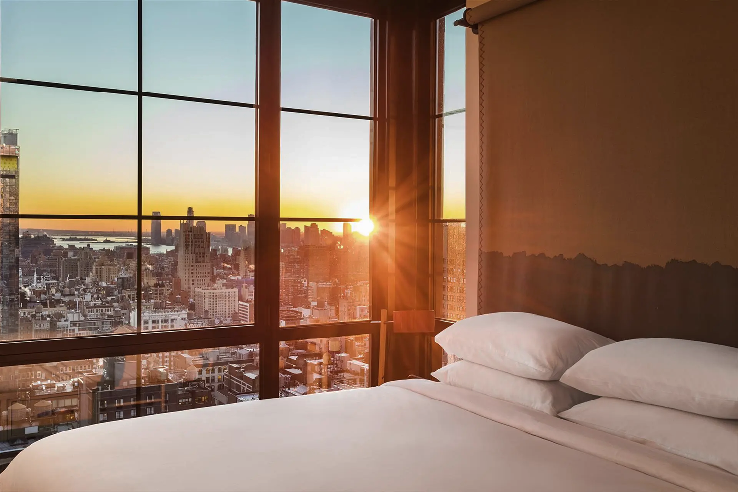 Les hôtels Moxy à New York, le meilleur rapport qualité/prix de la ville : chambre avec vue sur la skyline de Manhattan et son coucher de soleil